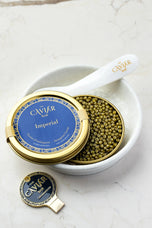 Imperial Caviar tin in white bowl with mother-of-pearl spoon