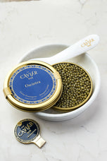 Oscietra Caviar tin in white bowl with mother-of-pearl spoon
