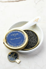 Royal Baerii Caviar tin in white bowl with mother-of-pearl spoon