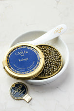Royal Kaluga Caviar tin in white bowl with mother-of-pearl spoon
